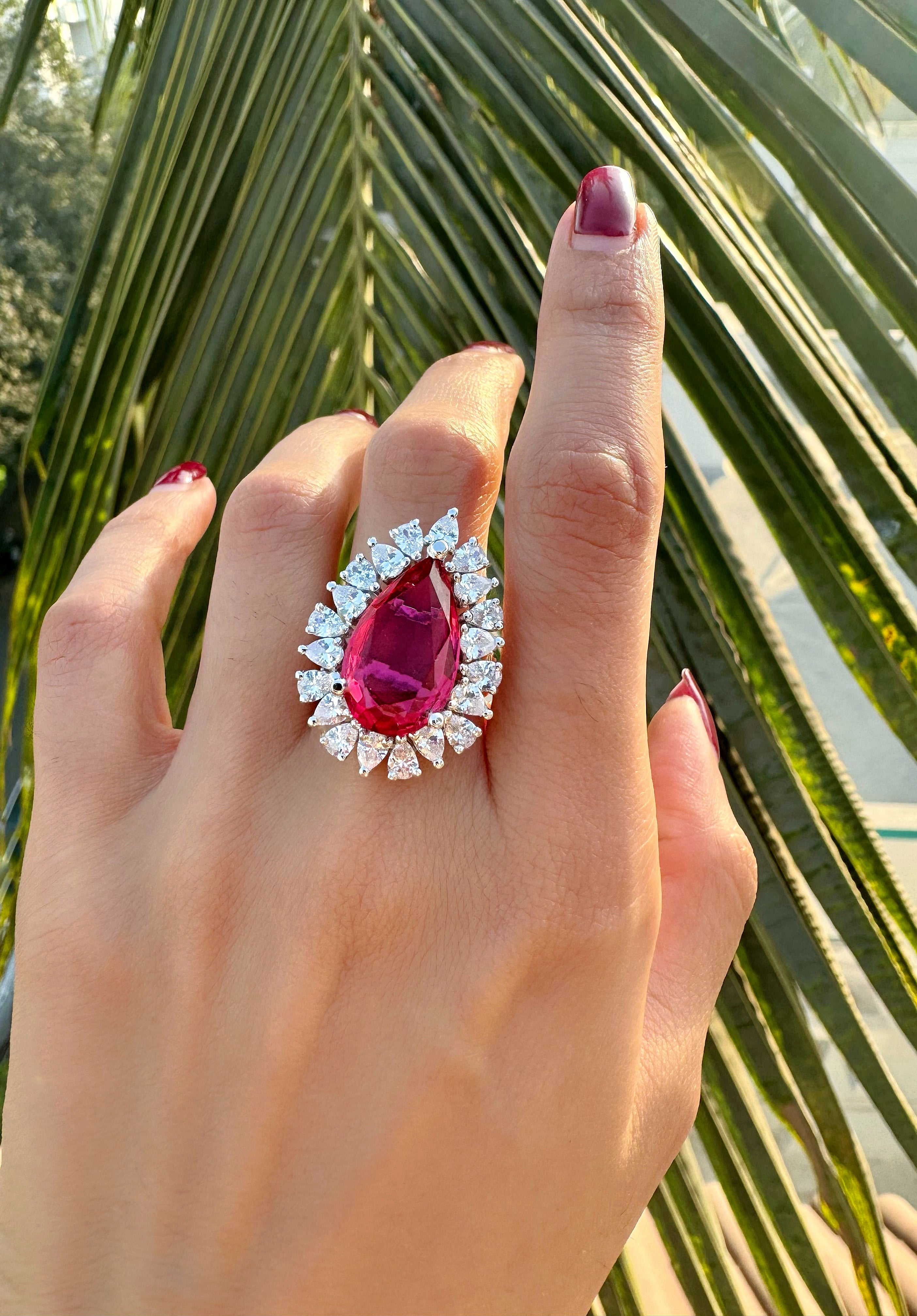 Fancy pink tourmaline pear halo statement ring worn on hand in 925 sterling silver
